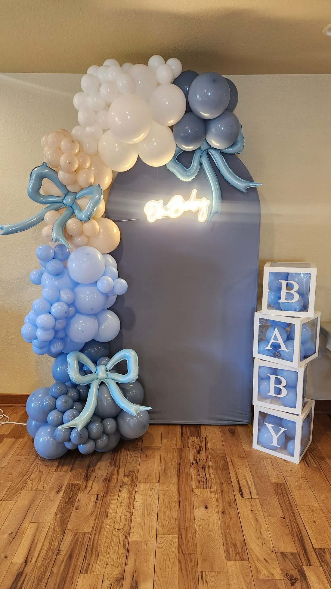 Baby shower installation in soft blue and ivory with balloon bows and lettered blocks