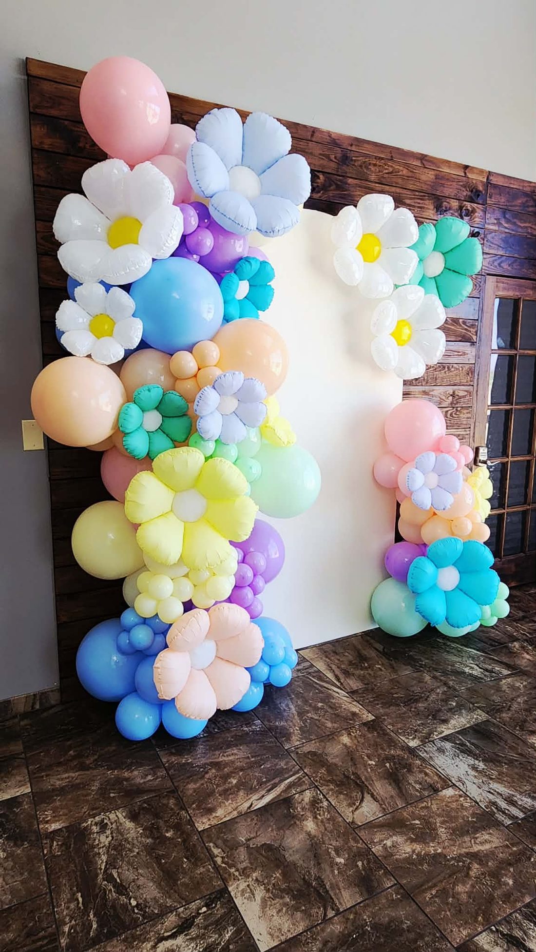 Pastel balloon garland with daisy accents in blush, lavender and sky blue