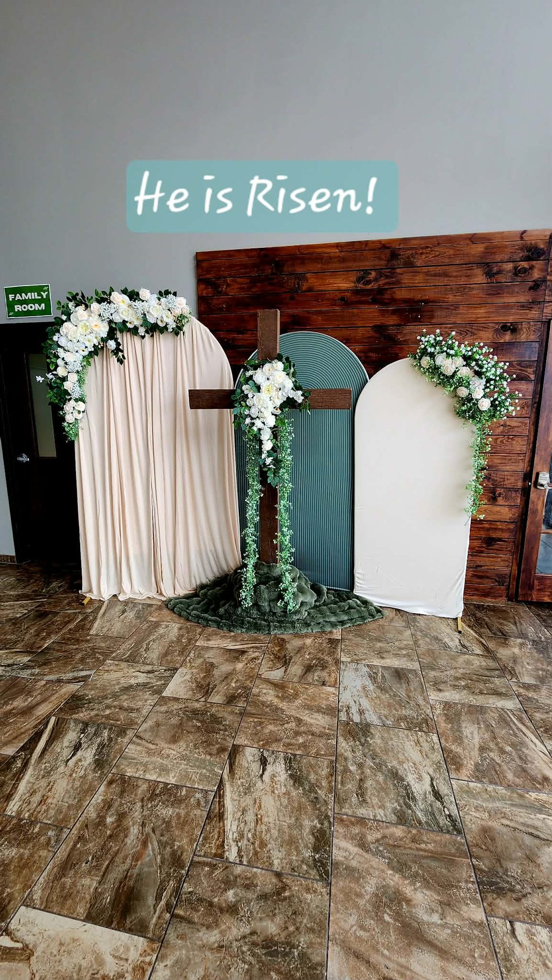 Arched panel backdrop with greenery and ivory florals for a spring celebration