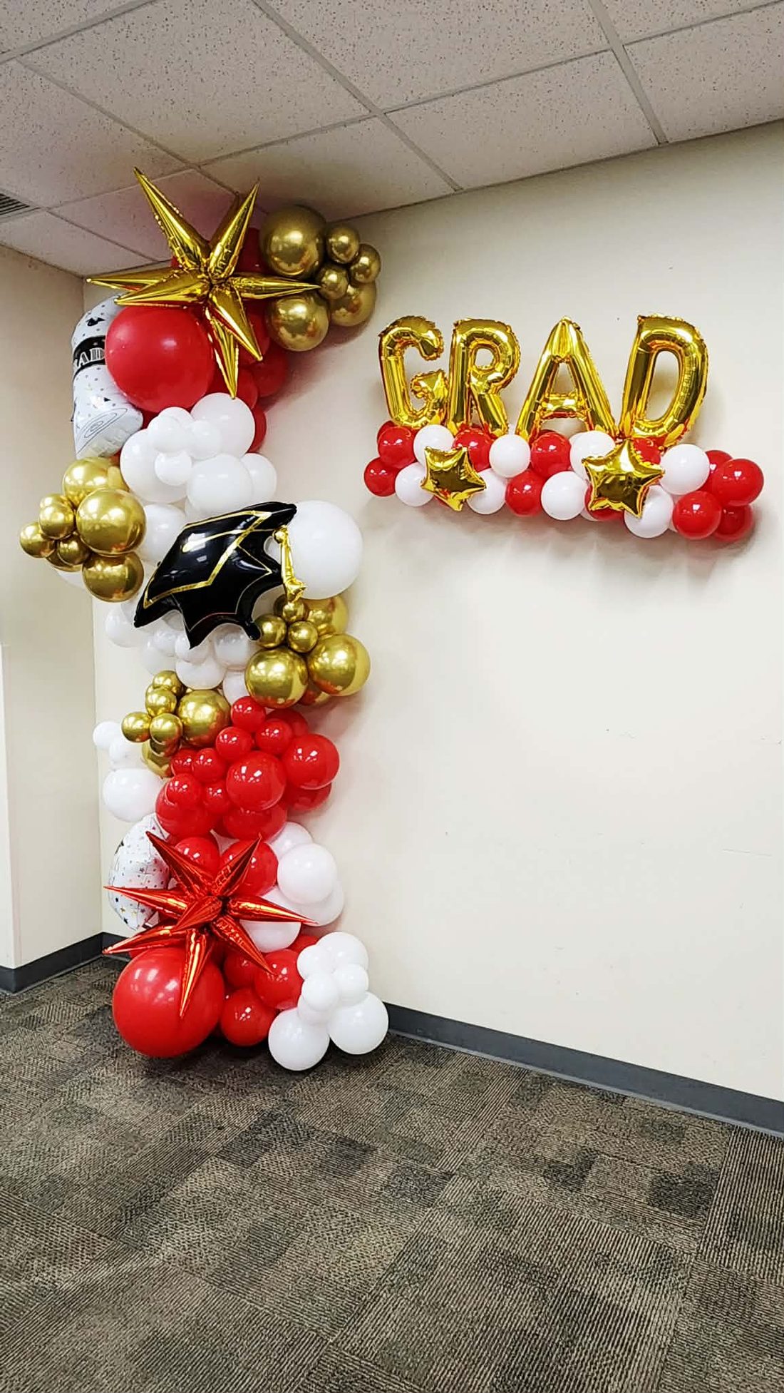 Graduation balloon column in red, ivory and gold with a graduation cap balloon